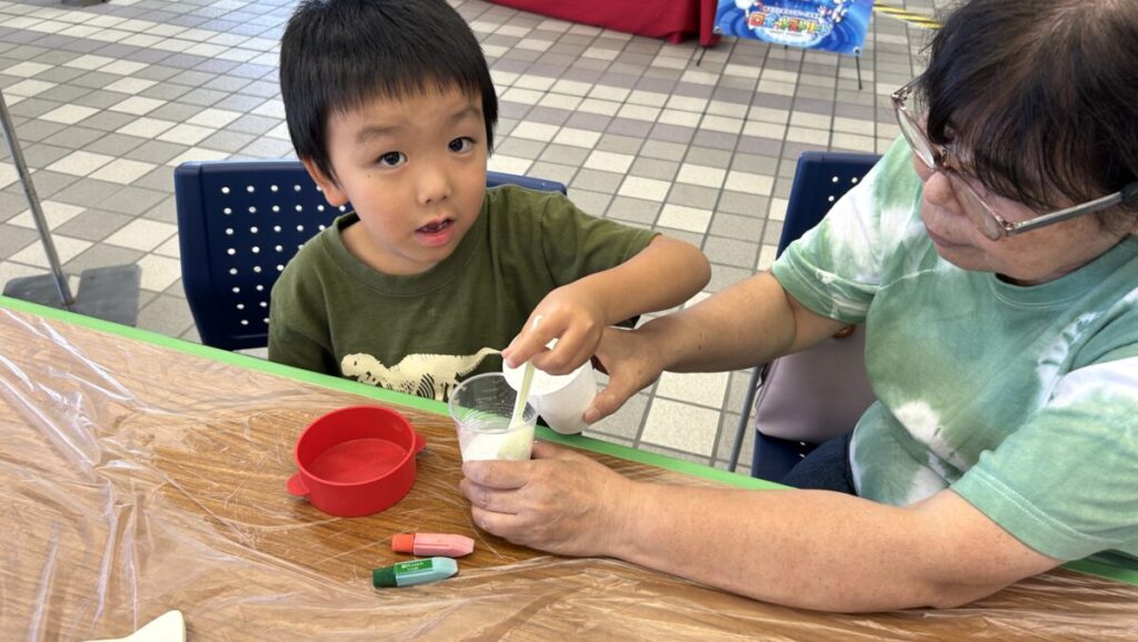 男の子がおばあちゃんと一緒にコースター作りに取組む様子